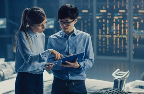 np_Male and Female Automobile Design Electric Car Engineers Having Conversation, Use Clipboard to Check Maintenance Issues._5oW9wz_free